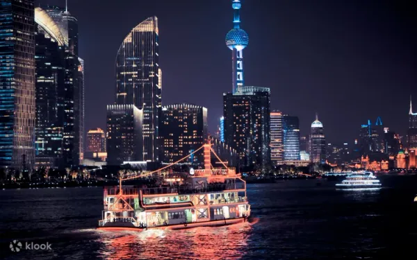 Illuminated cruise boat on Huangpu River at night with Shanghai's glowing skyscrapers and Oriental Pearl Tower creating dramatic city skyline backdropRetry